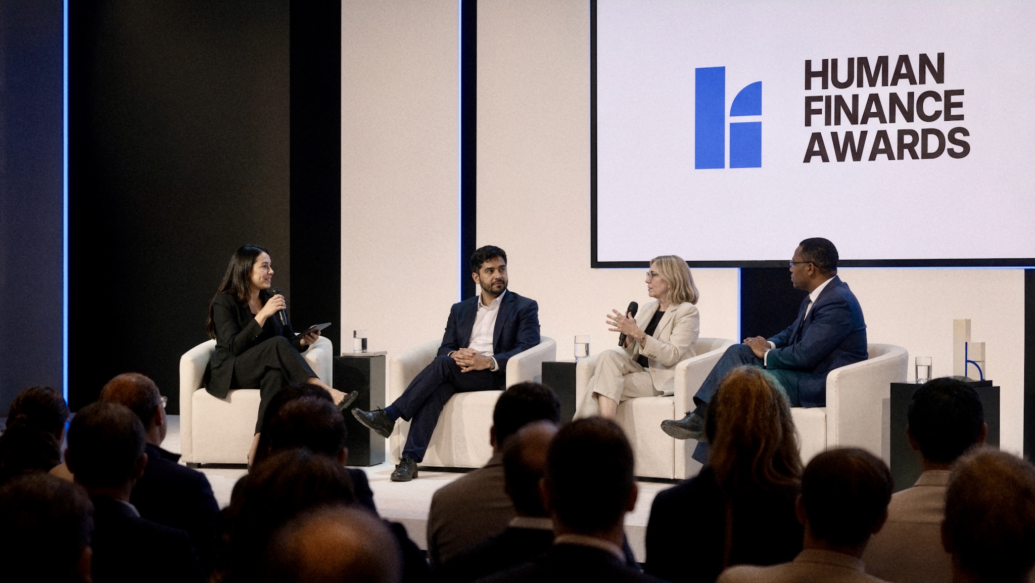Four speakers in conversation onstage at the Human Finance Awards.